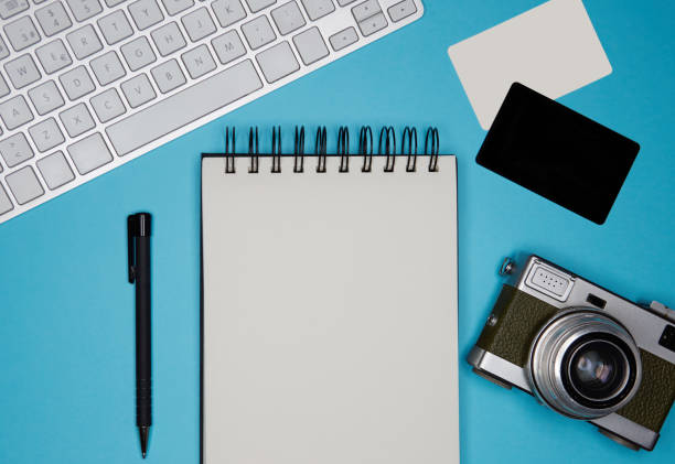 istock Mockup of two blank business cards, paper note book, computer keyboard on empty color desk. Business empty mock-up background for message writing.Top view. 1069163706
