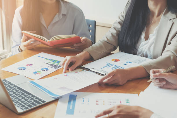 istock Business People Meeting using laptop computer,calculator,notebook,stock market chart paper for analysis Plans to improve quality next month. 1069166290