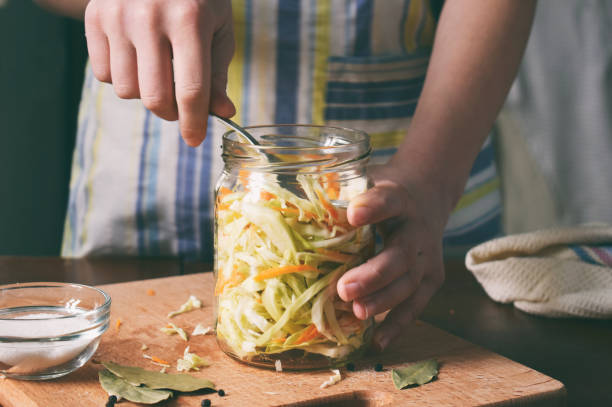 choucroute de cuisinier de femme ou de la salade sur fond en bois. étape 5 - mettre le chou dans les cuves. concept de goût fermenté de légumes déshydratés. - sauerkraut photos et images de collection