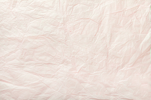 Texture of crumpled white wrapping paper, closeup. Pearl old background material.
