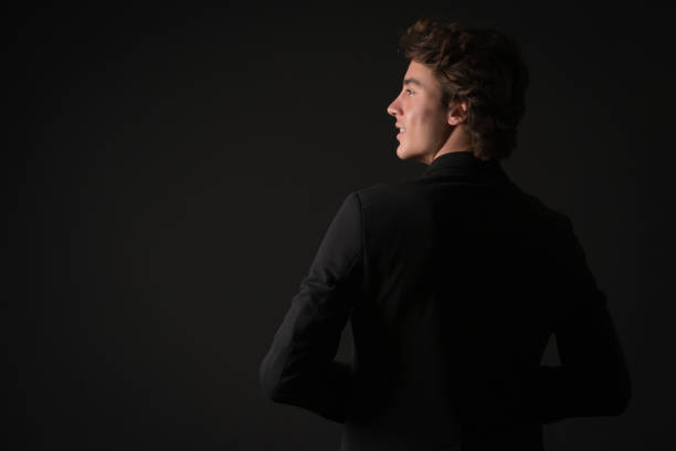 Portrait of smiling young cool man over black background