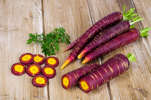 Sliced purple carrot on wooden background. Studio Photo