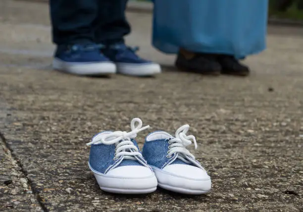 Pregnancy Announcement Outdoors With Baby Shoes