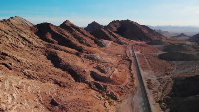 Aerial Drone Shot of Red Desert Mountains Next to Lake Mead Road (Road Leading into and Out of Las Vegas, Nevada)