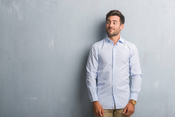 istock Handsome young business man over grey grunge wall wearing elegant shirt smiling looking side and staring away thinking. 1069183708