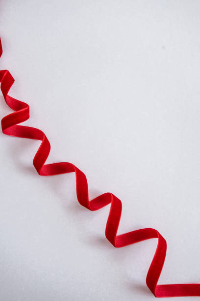 istock Red velvet curled ribbon on white 1069185592