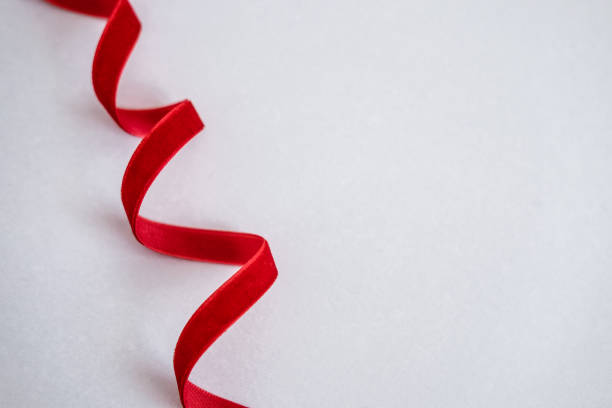 istock Red velvet curled ribbon on white 1069185598