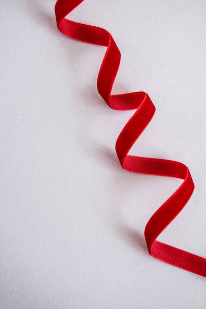 istock Red velvet curled ribbon on white 1069185610