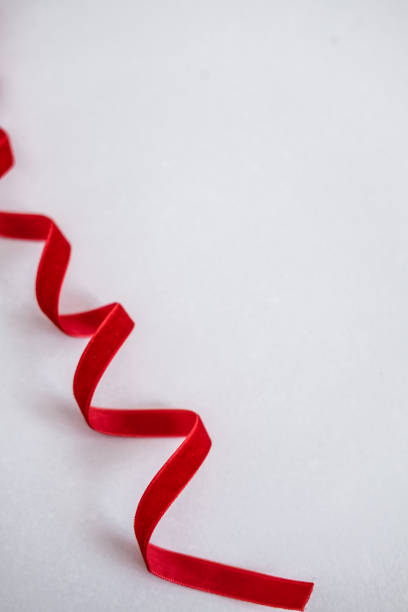 istock Red velvet curled ribbon on white 1069185668