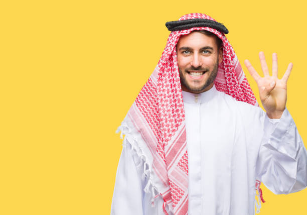 istock Young handsome man wearing keffiyeh over isolated background showing and pointing up with fingers number four while smiling confident and happy. 1069188436