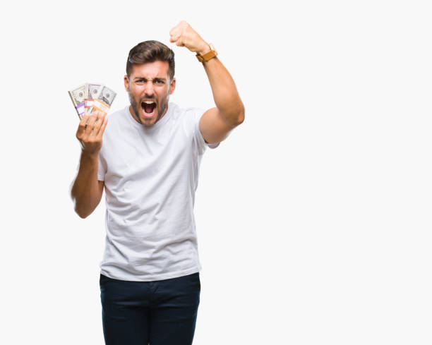 istock Young handsome man holding stack of dollars over isolated background annoyed and frustrated shouting with anger, crazy and yelling with raised hand, anger concept 1069189654