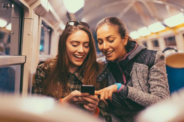 filles de surfer sur les médias sociaux dans la rame de métro - paris metro train photos et images de collection