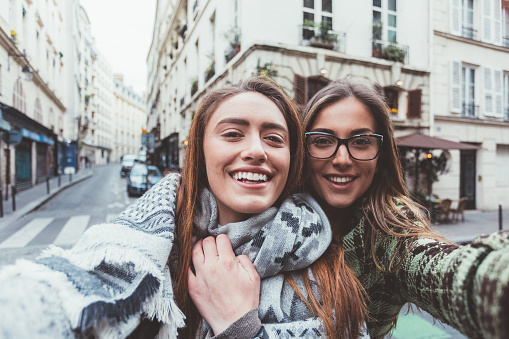 Happy friends taking selfie at the street in Paris during the spring season