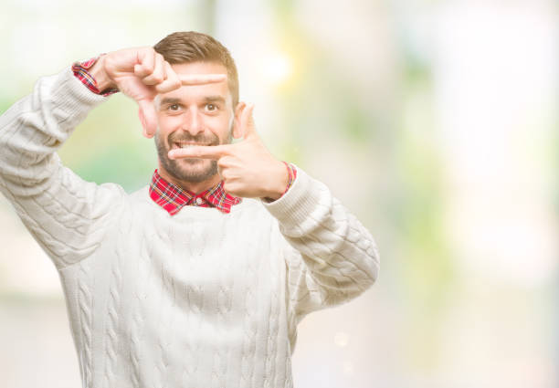 istock Young handsome man wearing winter sweater over isolated background smiling making frame with hands and fingers with happy face. Creativity and photography concept. 1069193070