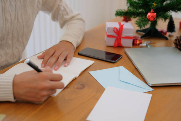 istock man writing note on notebook at home during christmas new year holiday celebration. 1069193126