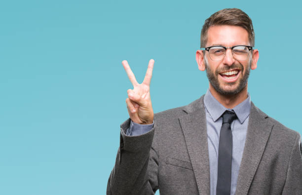 istock Young handsome business man over isolated background smiling with happy face winking at the camera doing victory sign. Number two. 1069193380