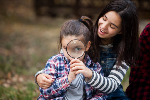istock cute girl looking through magnifying glass 1069199844