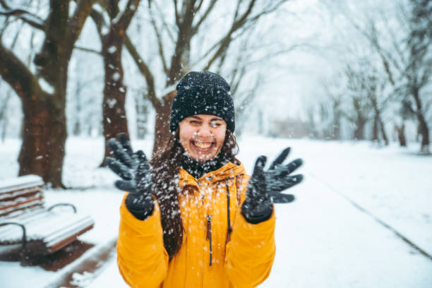 kobieta bawiąc się śniegiem w zaśnieżonym parku miejskim - christmas women human lips female zdjęcia i obrazy z banku zdjęć