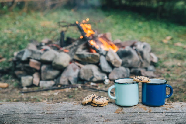 istock two metal cups with tea and cookies. fire on background 1069202040