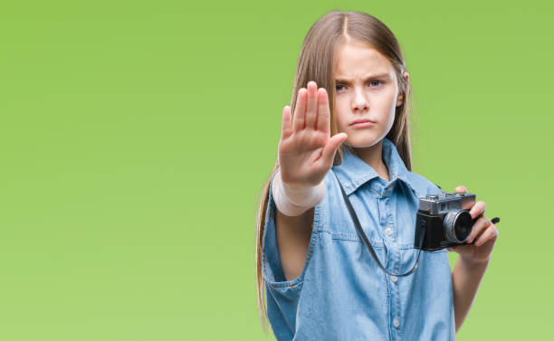 istock Young beautiful girl taking photos using vintage camera over isolated background with open hand doing stop sign with serious and confident expression, defense gesture 1069202228