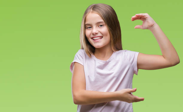 istock Young beautiful girl over isolated background gesturing with hands showing big and large size sign, measure symbol. Smiling looking at the camera. Measuring concept. 1069205312