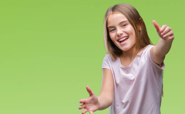 istock Young beautiful girl over isolated background looking at the camera smiling with open arms for hug. Cheerful expression embracing happiness. 1069205362