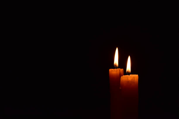 istock Yellow light candle burning brightly in the black background. 1069205374