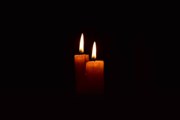 istock Yellow light candle burning brightly in the black background. 1069205442