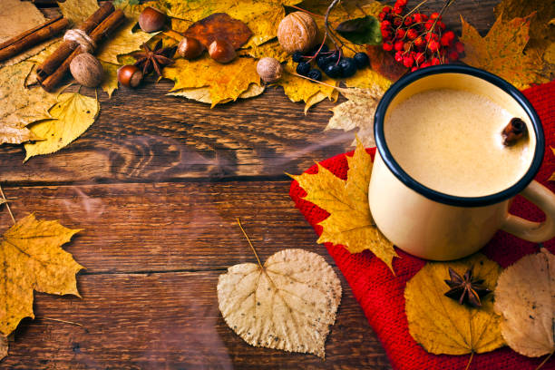 istock Coffee in an enamel mug with a scarf, leaves, nuts and spices. 1069210654