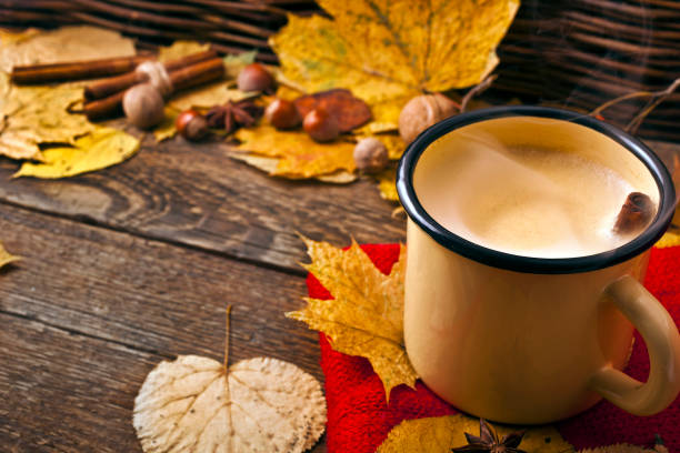 istock Coffee in an enamel mug with a scarf, leaves, nuts and spices. 1069210704
