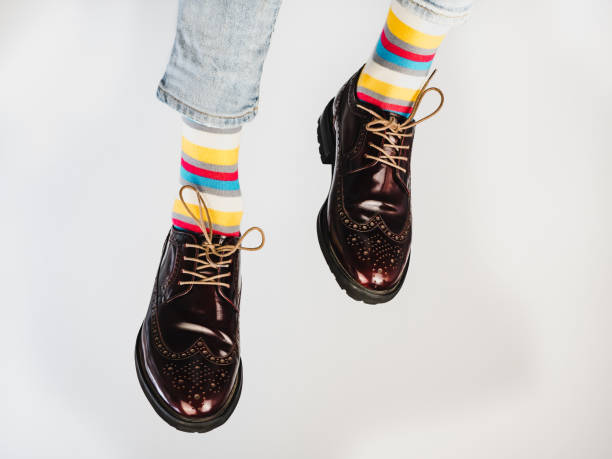 istock Men's legs in bright, striped, multi-colored socks 1069213870