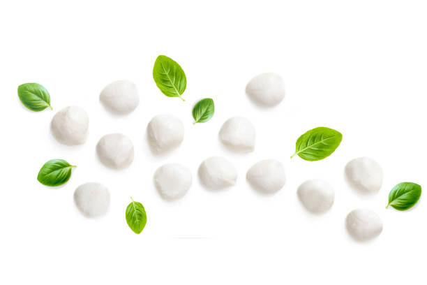 Composition with Mozzarella and  basil leaf isolated  on white background. Traditional Italian Mozzarella cheese balls close up. Top view
