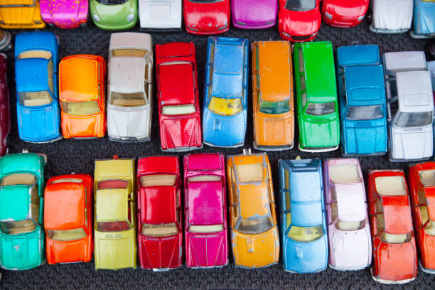 Collection of different  types of used toy cars on wooden background.