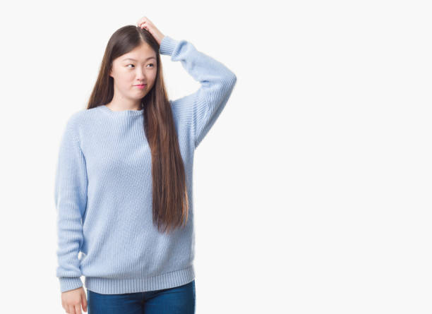 istock Young Chinese woman over isolated background confuse and wonder about question. Uncertain with doubt, thinking with hand on head. Pensive concept. 1069220992