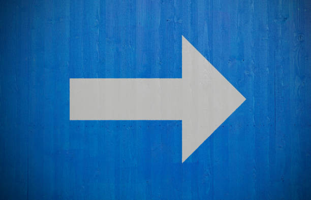 istock Arrow painted on fresh clean newly painted blue wooden plank wall 1069227660