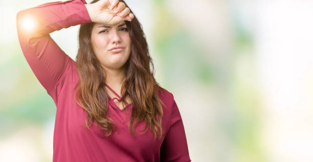 istock Beautiful plus size young woman over isolated background Touching forehead for illness and fever, flu and cold, virus sick 1069233234