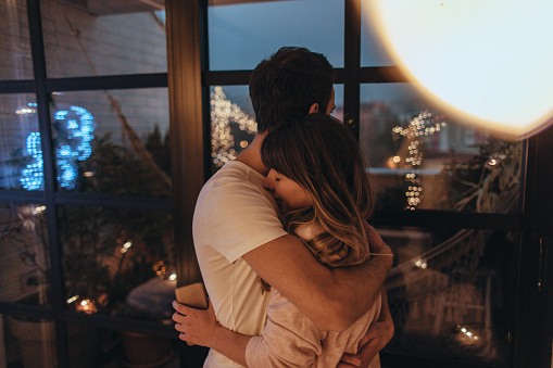 Photo of young couple in their apartment during Christmas holidays