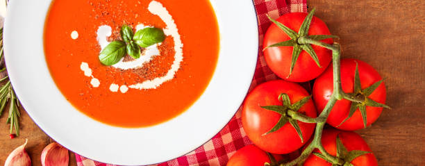 istock Tomato Soup composition with fresh tomatoes, basil leaf and garlic on a wood table, view from above. Vegetarian Autumn Food 1069235582