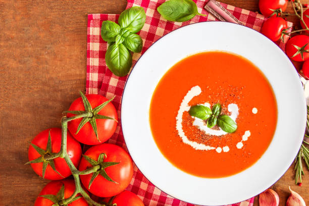 istock Tomato Soup composition with fresh tomatoes, basil leaf and garlic on a wood table, view from above. Vegetarian Autumn Food 1069235924