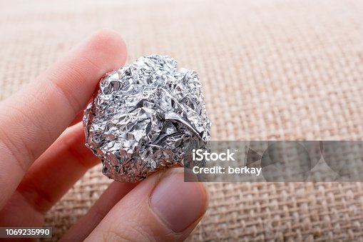 istock Aluminium foil in the shape of a sphere on  textured background 1069235990