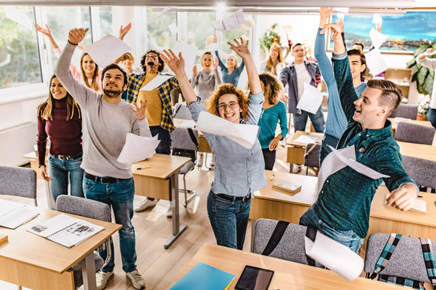 istock Large group of joyful students throwing papers while celebrating the end of a school year. 1069238936