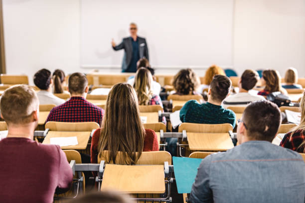 fotografii de stoc, fotografii și imagini scutite de redevențe cu vedere din spate a unui grup mare de elevi într-o clasă la sala de curs. - skynesher