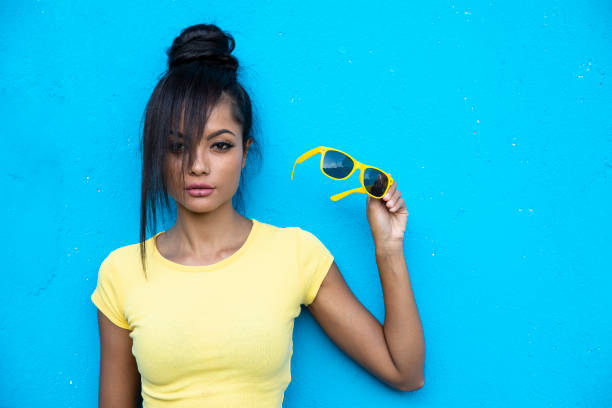 istock Young woman holding yellow sunglasses 1069240896