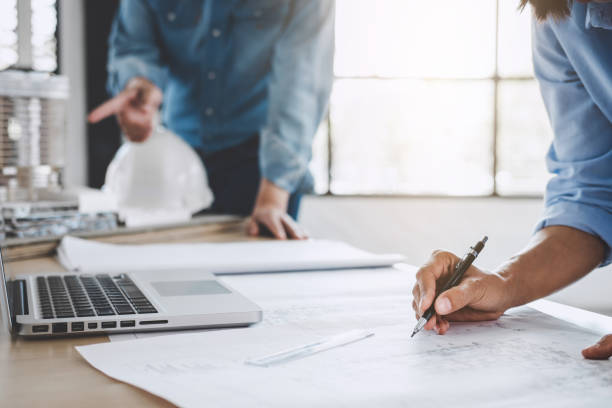 istock Construction concept of Engineer or architect meeting for project working with partner and engineering tools on model building and blueprint in working site 1069241240