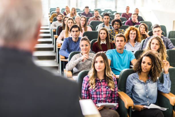 große gruppe von college-studenten anhören ihres professors für eine klasse. - lecture hall university student seminar stock-fotos und bilder