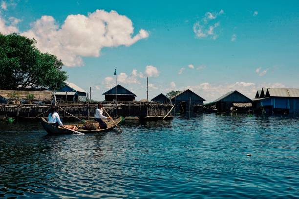 ragazze locali che vanno a scuola con una canoa tradizionale sul lago - flood people asia cambodia foto e immagini stock