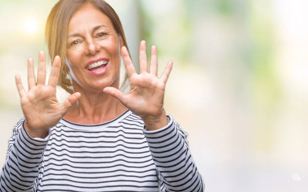 istock Middle age senior hispanic woman over isolated background showing and pointing up with fingers number ten while smiling confident and happy. 1069249232