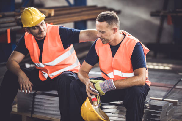 Don't worry colleague, everything is going to be ok! Sad manual worker being consoled by his colleague in aluminum mill. Dont stock pictures, royalty-free photos & images