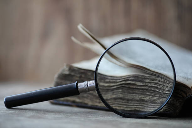 istock Old books on a wooden table and magnifier 1069250852