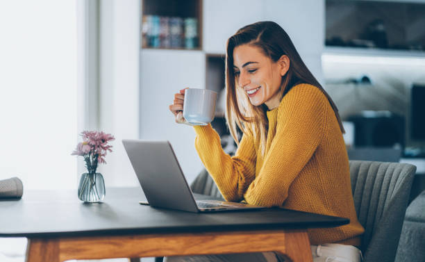 młoda kobieta biuro domowe - looking at laptop zdjęcia i obrazy z banku zdjęć